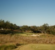 The short par-3 seventh at Cordillera Ranch Golf Club features a small green surrounded by bunkers.