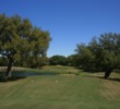 From the tee, the eighth green on the Oaks nine at Hill Country Golf Club is tucked between two oaks and over a pond. 