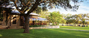 A view of the clubhouse with putting green on the right at Fair Oaks Ranch Golf & Country Club